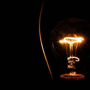 Illuminated lightbulb filament set against dark background